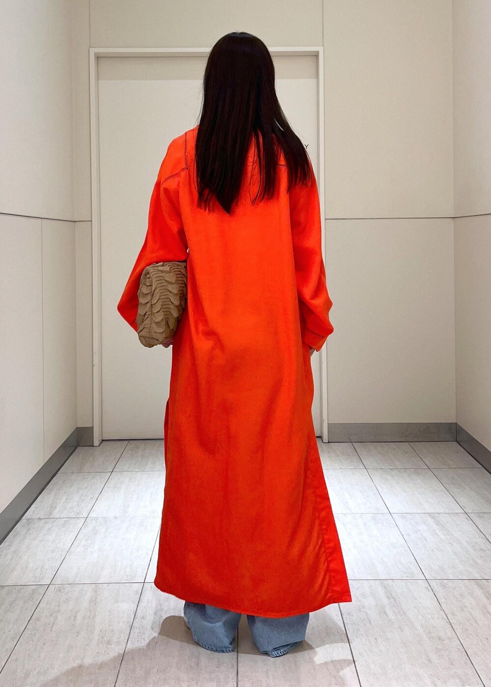 ブルー系のデニムパンツ、レッド系のワンピース、シルバー系のサンダルを着用したレディースの春コーディネートの4枚目の写真