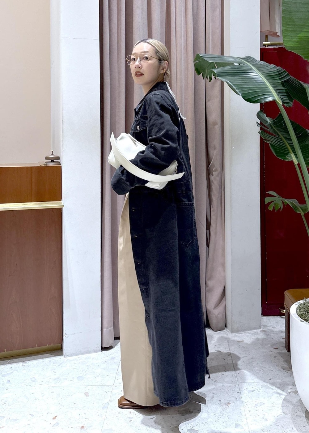 ホワイト系のハンドバッグ、ブラウン系のサンダル、ブラック系のワンピースを着用したレディースの春コーディネートの2枚目の写真