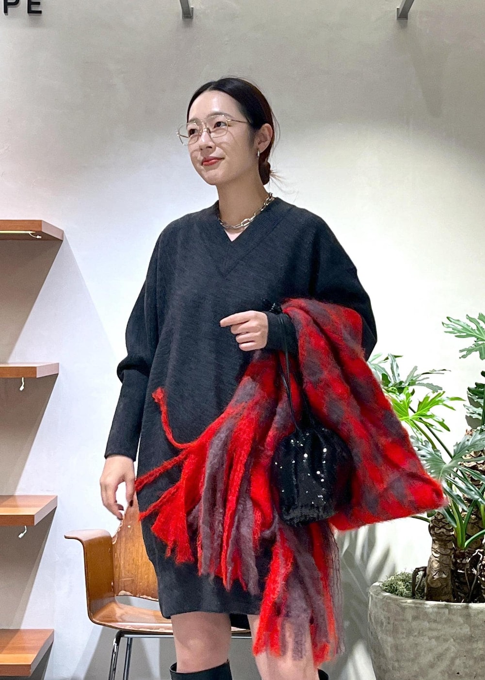 ブラック系のブーツ、グレー系のニット/セーター、ブラック系のハンドバッグを着用したレディースの秋コーディネートの4枚目の写真