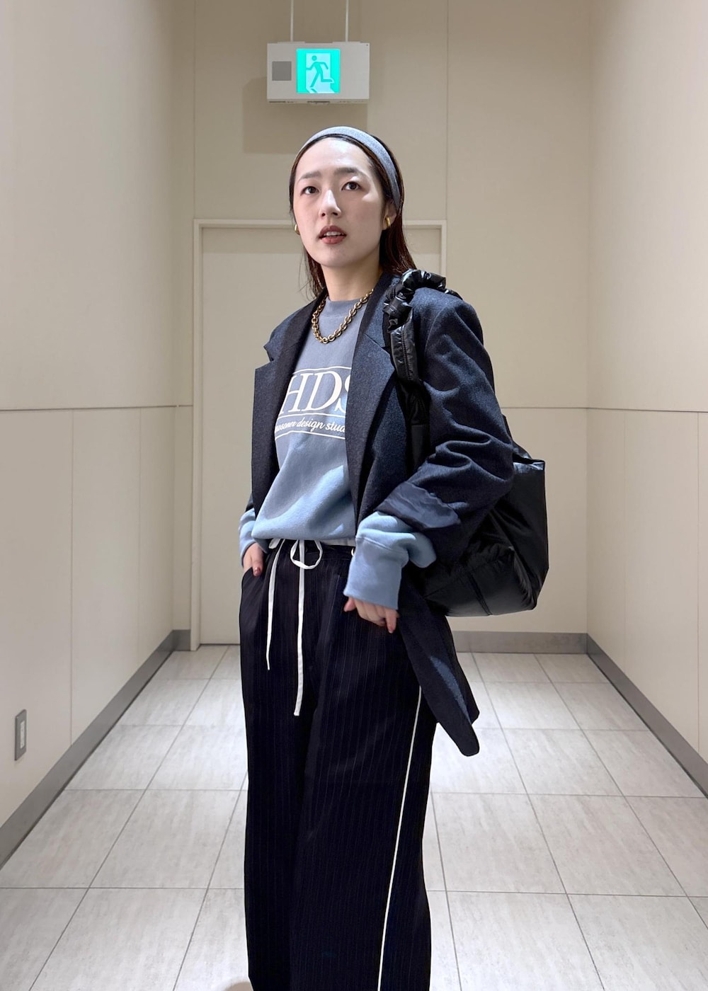 ブルー系のスウェット、ブラウン系のサンダル、グレー系のテーラードジャケットを着用したレディースの秋コーディネートの4枚目の写真