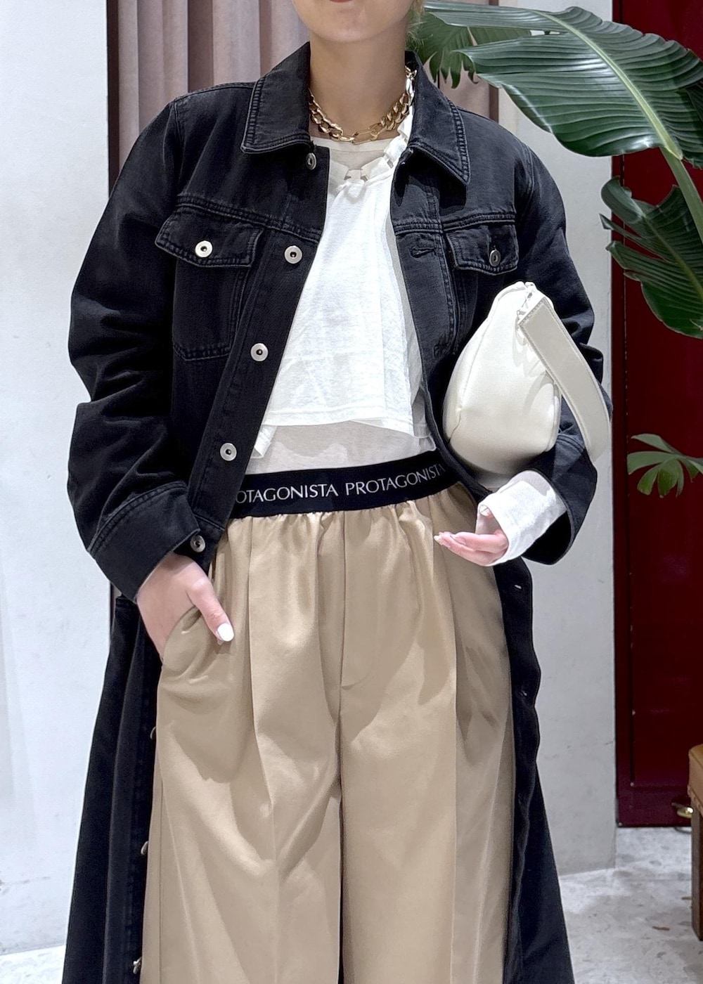 ホワイト系のハンドバッグ、ブラウン系のサンダル、ブラック系のワンピースを着用したレディースの春コーディネートの4枚目の写真