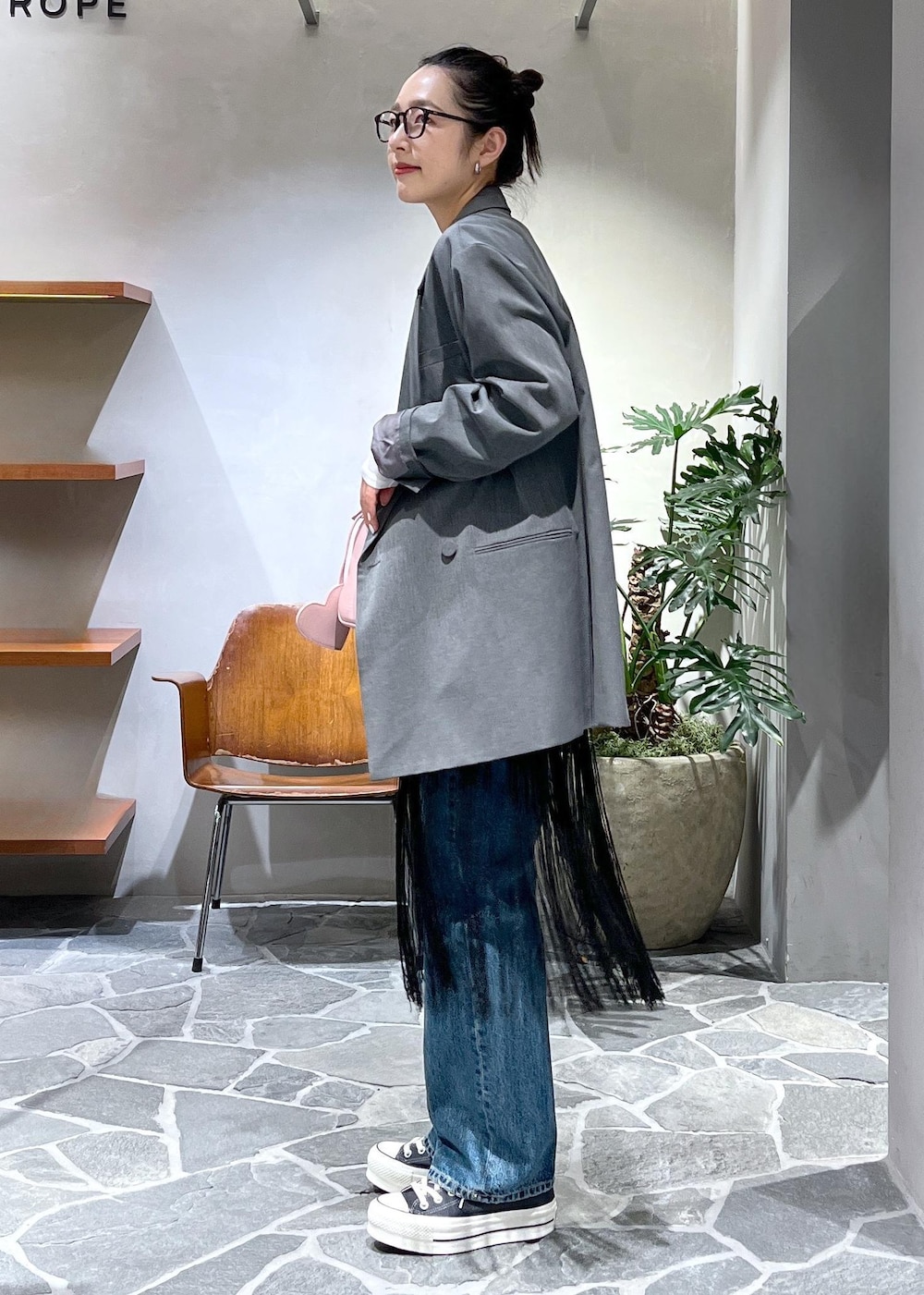 ピンク系のショルダーバッグ、ブルー系のデニムパンツ、ブラック系のスカートを着用したレディースの冬コーディネートの2枚目の写真