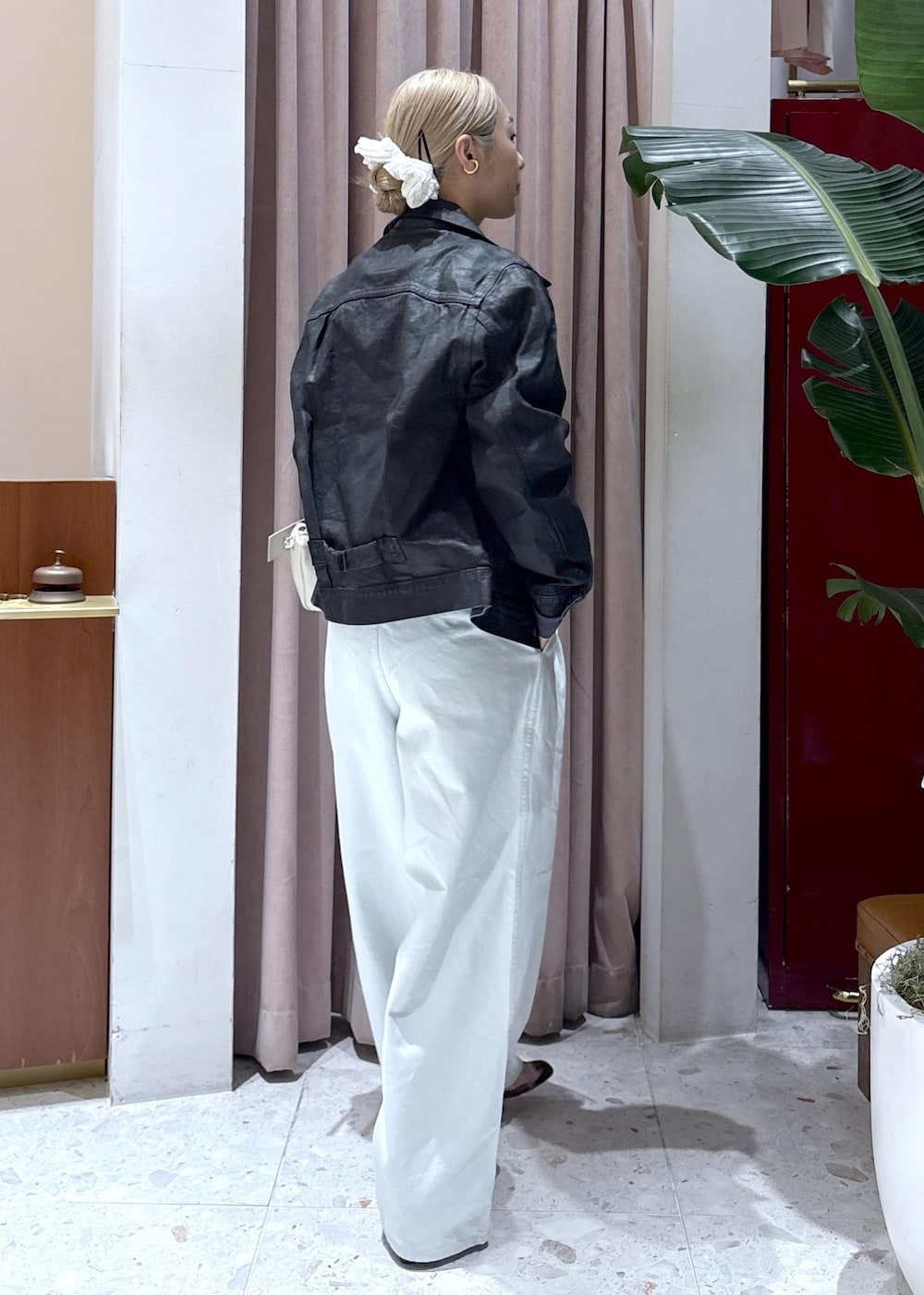 ホワイト系のハンドバッグ、グレー系のTシャツ/カットソー、ブルー系のデニムパンツを着用したレディースの冬コーディネートの3枚目の写真