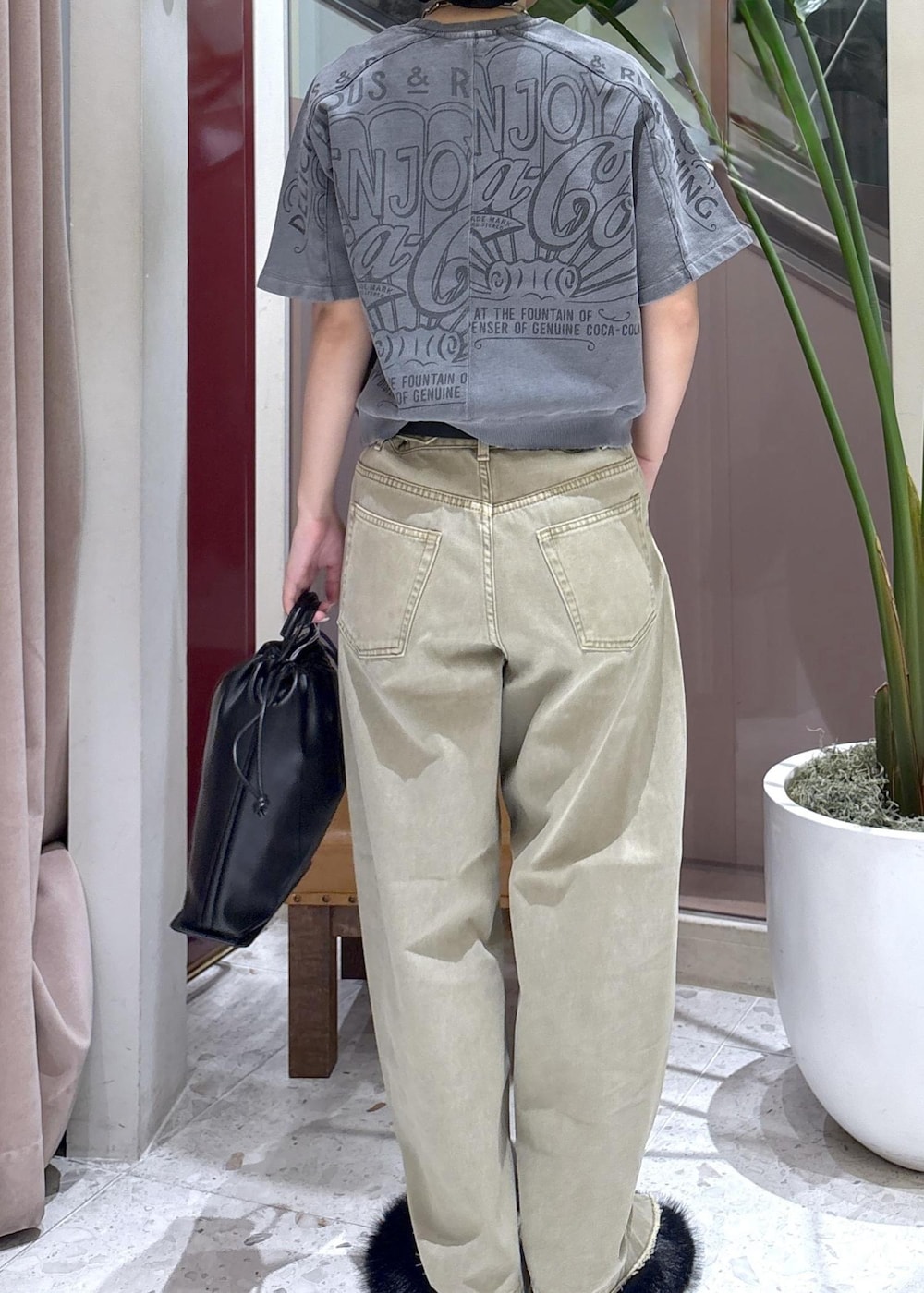 ベージュ系のデニムパンツ、ブラック系のサンダル、ブラック系のショルダーバッグを着用したレディースの夏コーディネートの3枚目の写真