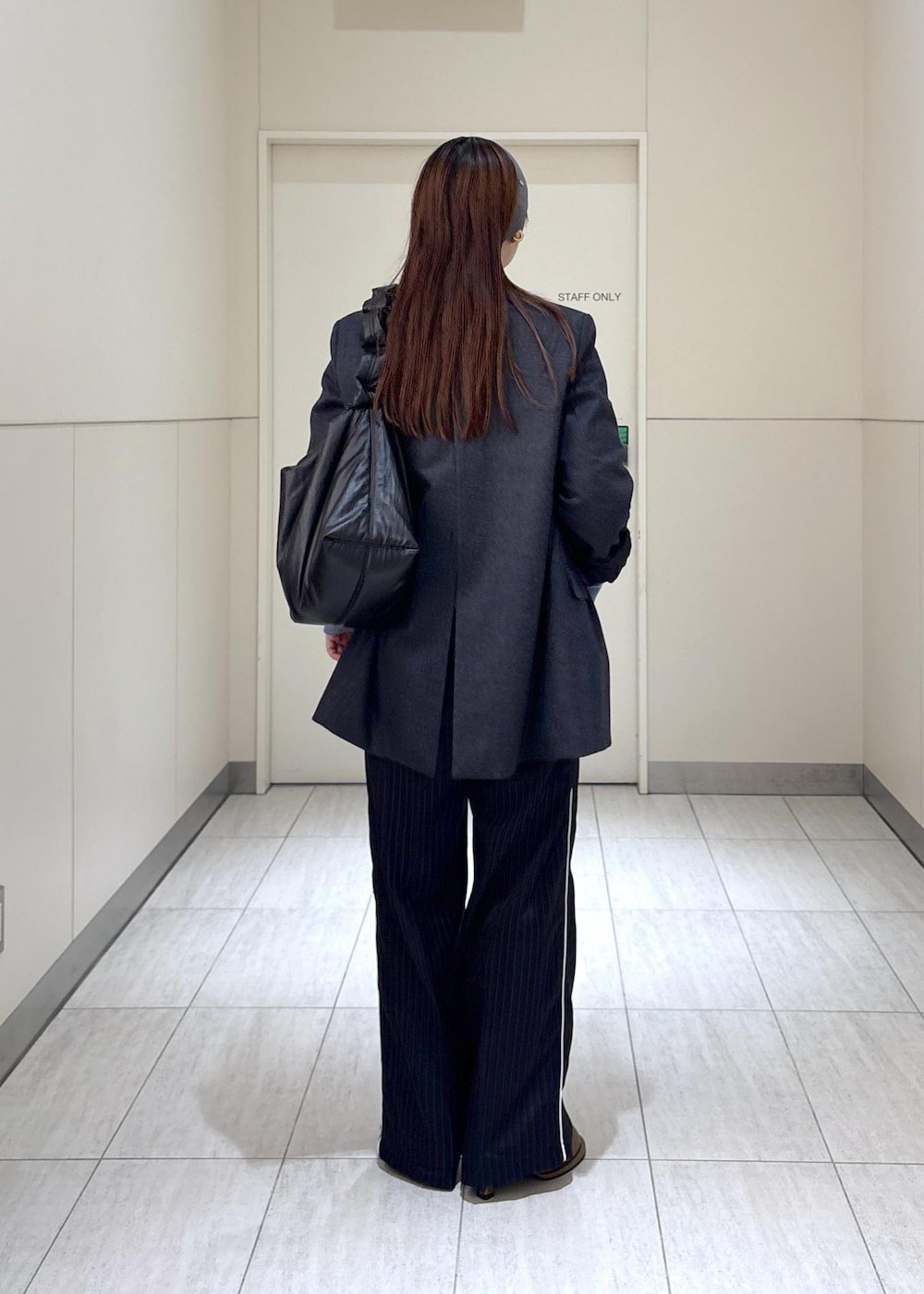 ブルー系のスウェット、ブラウン系のサンダル、グレー系のテーラードジャケットを着用したレディースの秋コーディネートの3枚目の写真