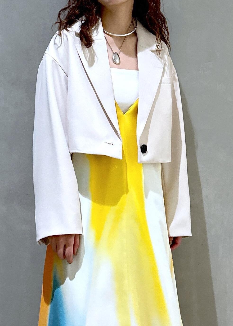 ホワイト系のサンダル、イエロー系のワンピース、ホワイト系のテーラードジャケットを着用したレディースの春コーディネートの5枚目の写真