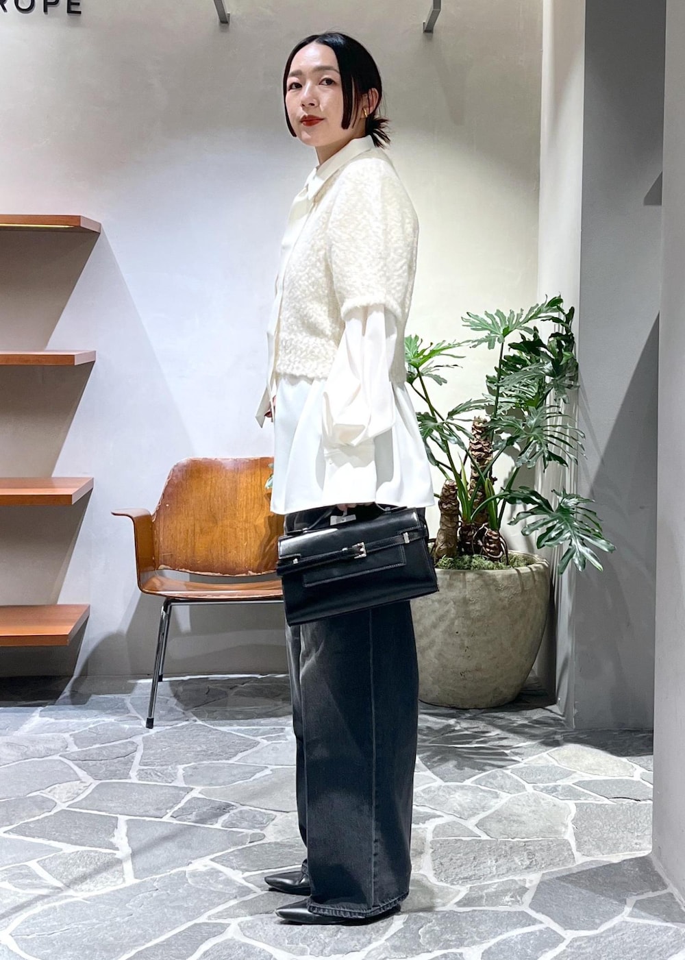 ホワイト系のシャツ/ブラウス、ホワイト系のニット/セーター、ブラック系のデニムパンツを着用したレディースの冬コーディネートの2枚目の写真