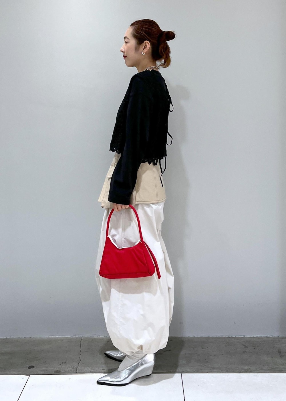 ブラック系のTシャツ/カットソー、ブラック系のベスト、ホワイト系のその他パンツを着用したレディースの冬コーディネートの2枚目の写真