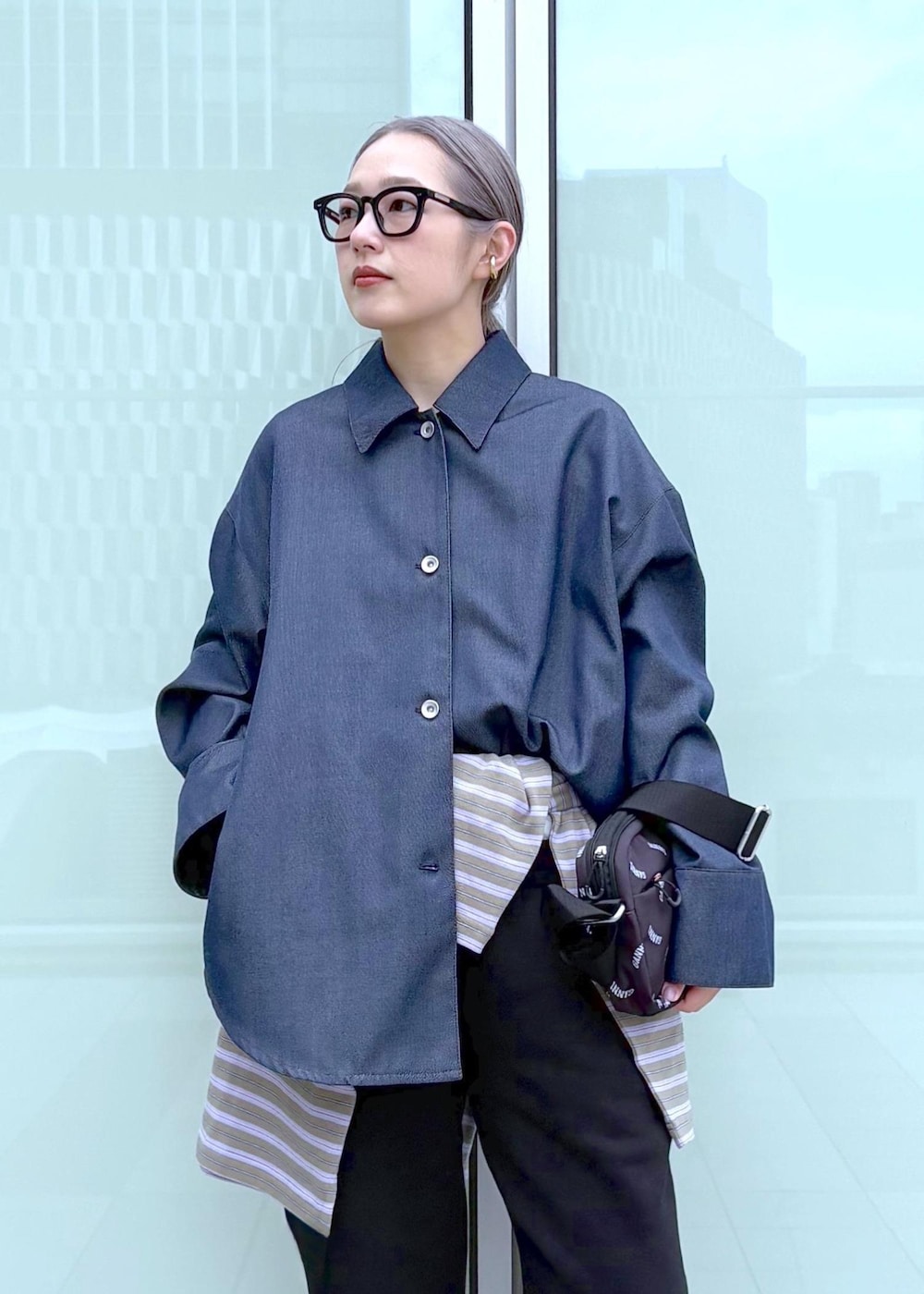 ブルー系のブルゾン、ブラック系のトートバッグ、パープル系のポロシャツを着用したレディースの冬コーディネートの5枚目の写真