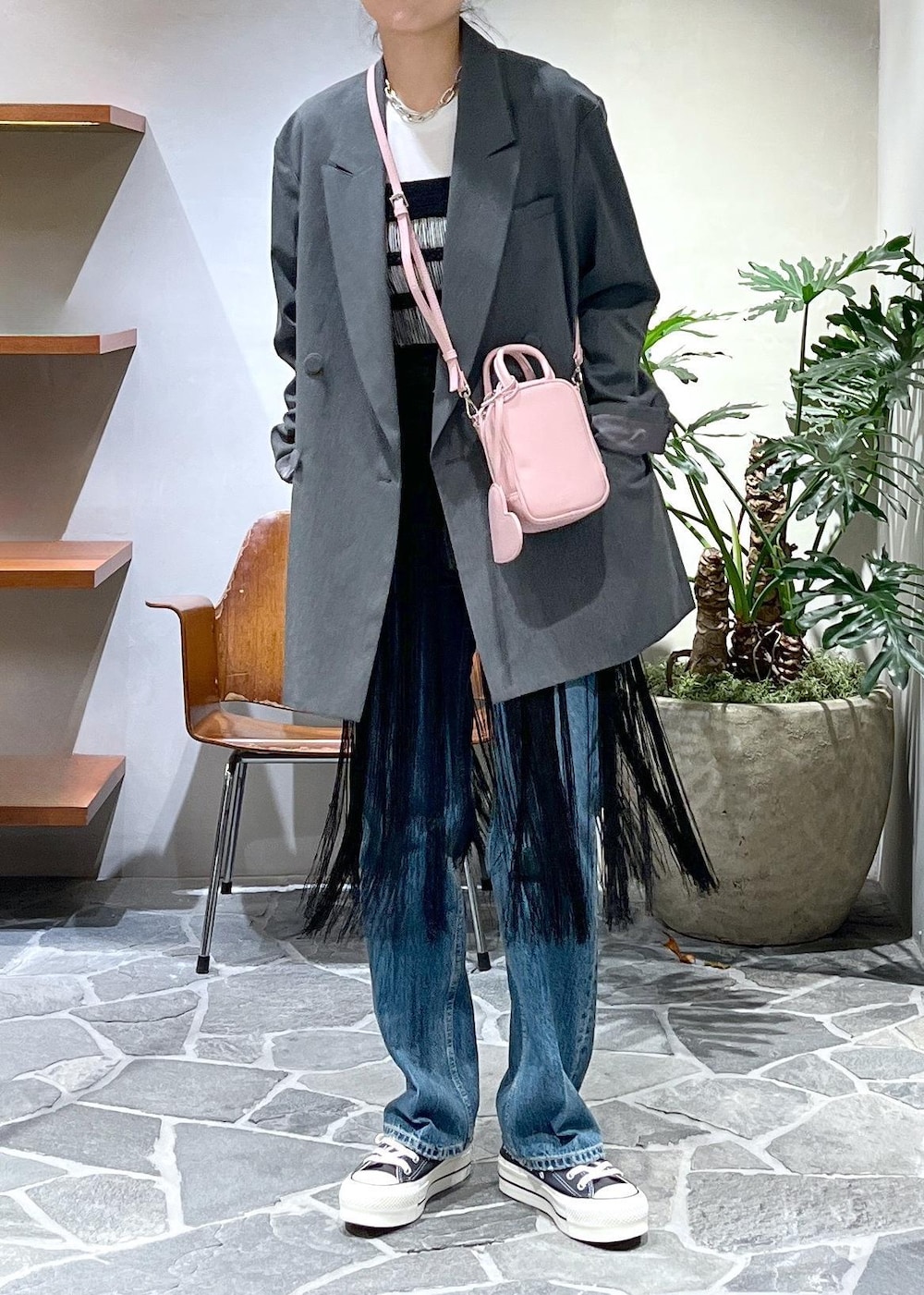 ピンク系のショルダーバッグ、ブルー系のデニムパンツ、ブラック系のスカートを着用したレディースの冬コーディネートの3枚目の写真