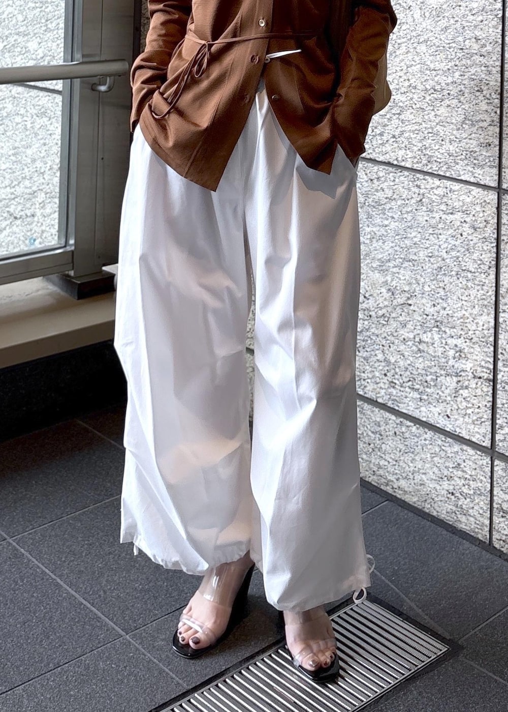 ベージュ系のショルダーバッグ、ブラウン系のカーディガン/ボレロを着用したレディースの春コーディネートの6枚目の写真