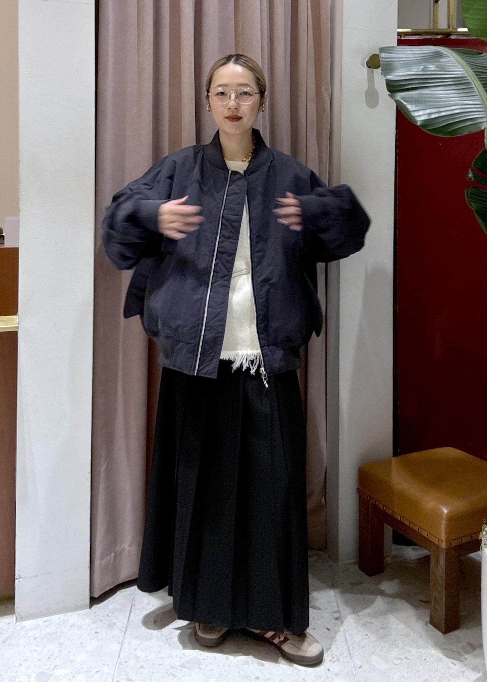 ブラック系のスカート、ベージュ系のスニーカー、ブルー系のMA-1を着用したレディースの冬コーディネートの2枚目の写真