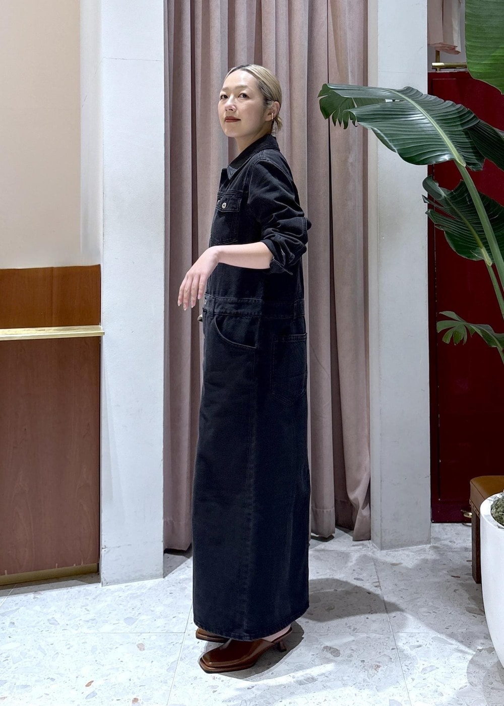 ブラウン系のサンダル、ブラック系のワンピースを着用したレディースの春コーディネートの2枚目の写真