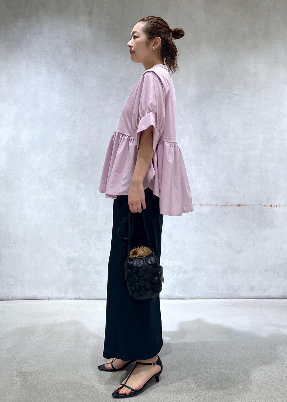 ブラック系のサンダル、ブラック系のスカート、ピンク系のTシャツ/カットソーを着用したレディースの春コーディネートの2枚目の写真