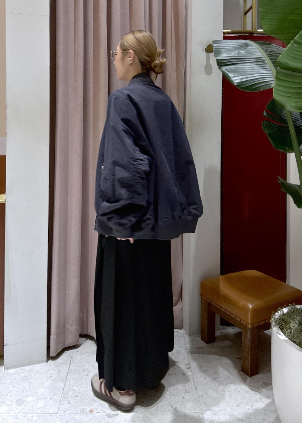 ブラック系のスカート、ベージュ系のスニーカー、ブルー系のMA-1を着用したレディースの冬コーディネートの4枚目の写真