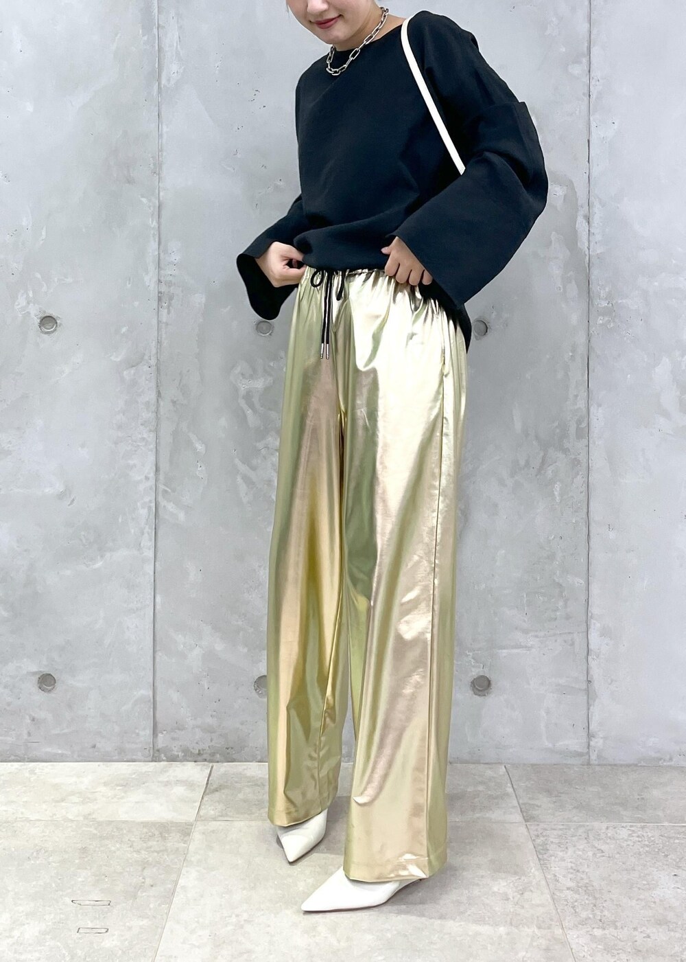 ホワイト系のパンプス、ブラック系のシャツ/ブラウス、ゴールド系のその他パンツを着用したレディースの秋コーディネートの2枚目の写真