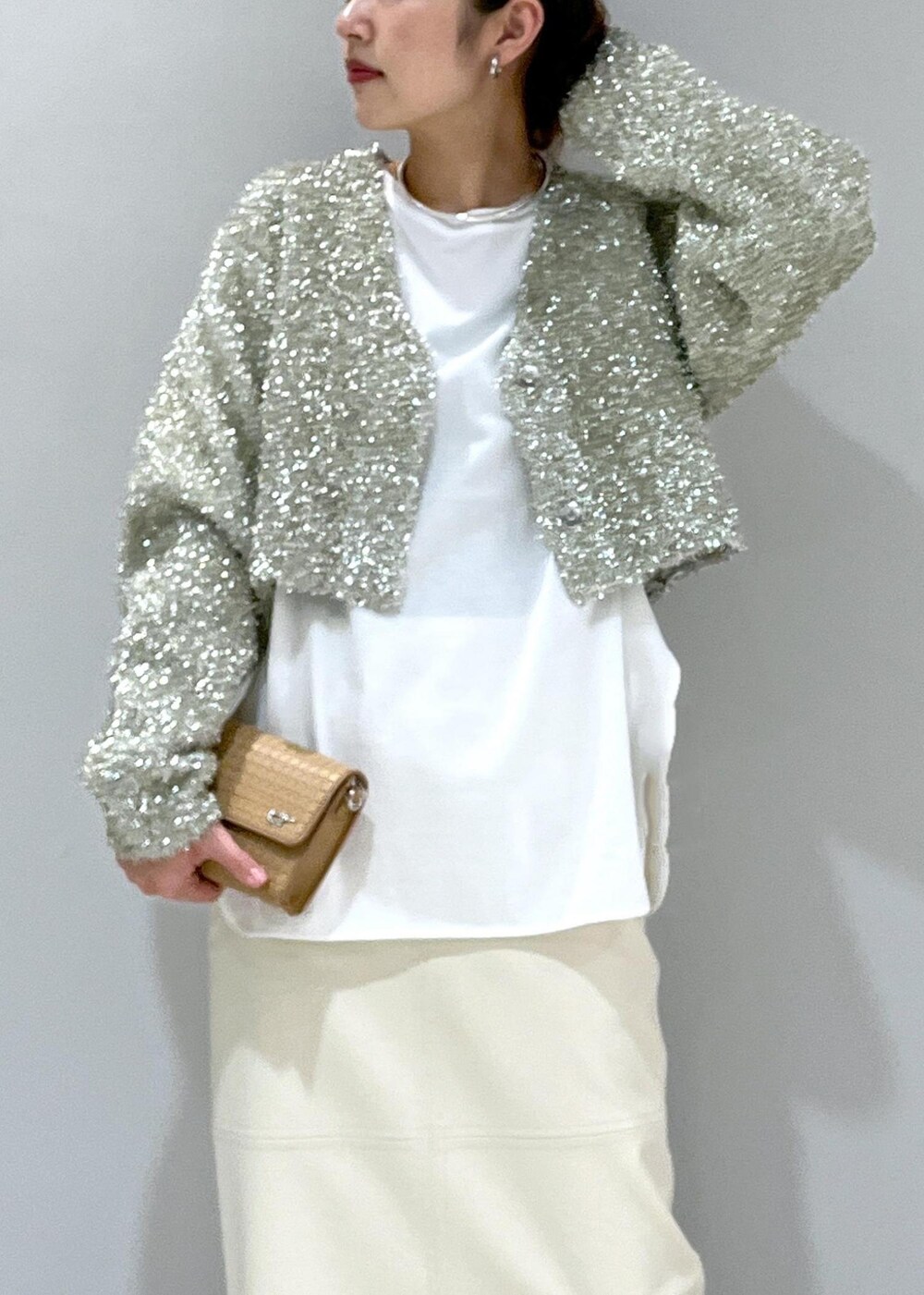 ホワイト系のスカート、ベージュ系のブーツ、ホワイト系のTシャツ/カットソーを着用したレディースの冬コーディネートの3枚目の写真