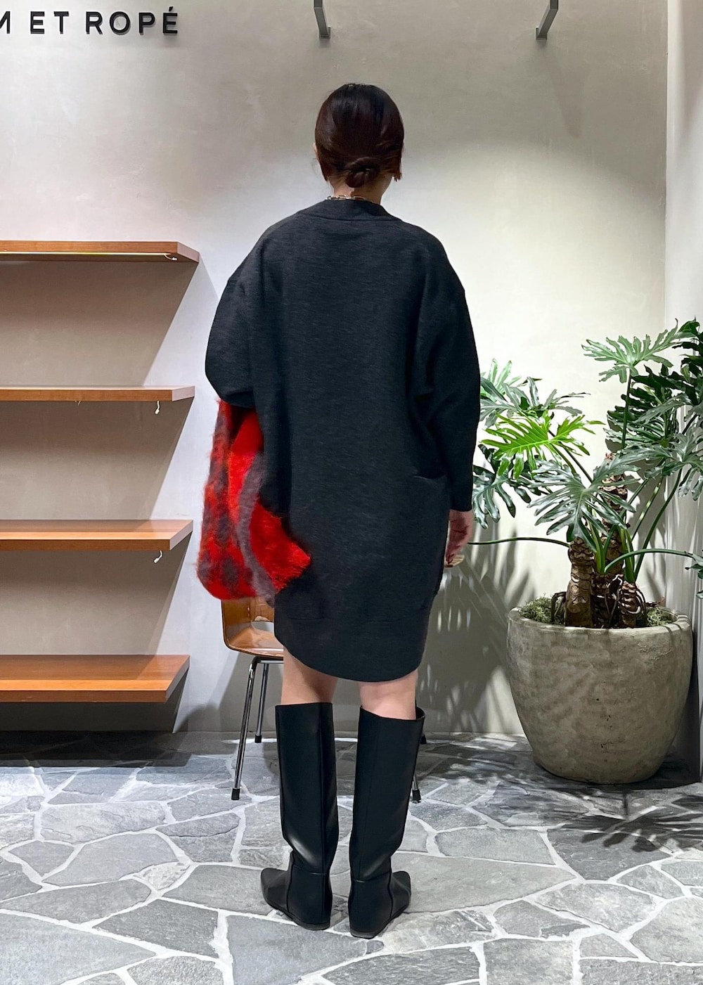 ブラック系のブーツ、グレー系のニット/セーター、ブラック系のハンドバッグを着用したレディースの秋コーディネートの3枚目の写真