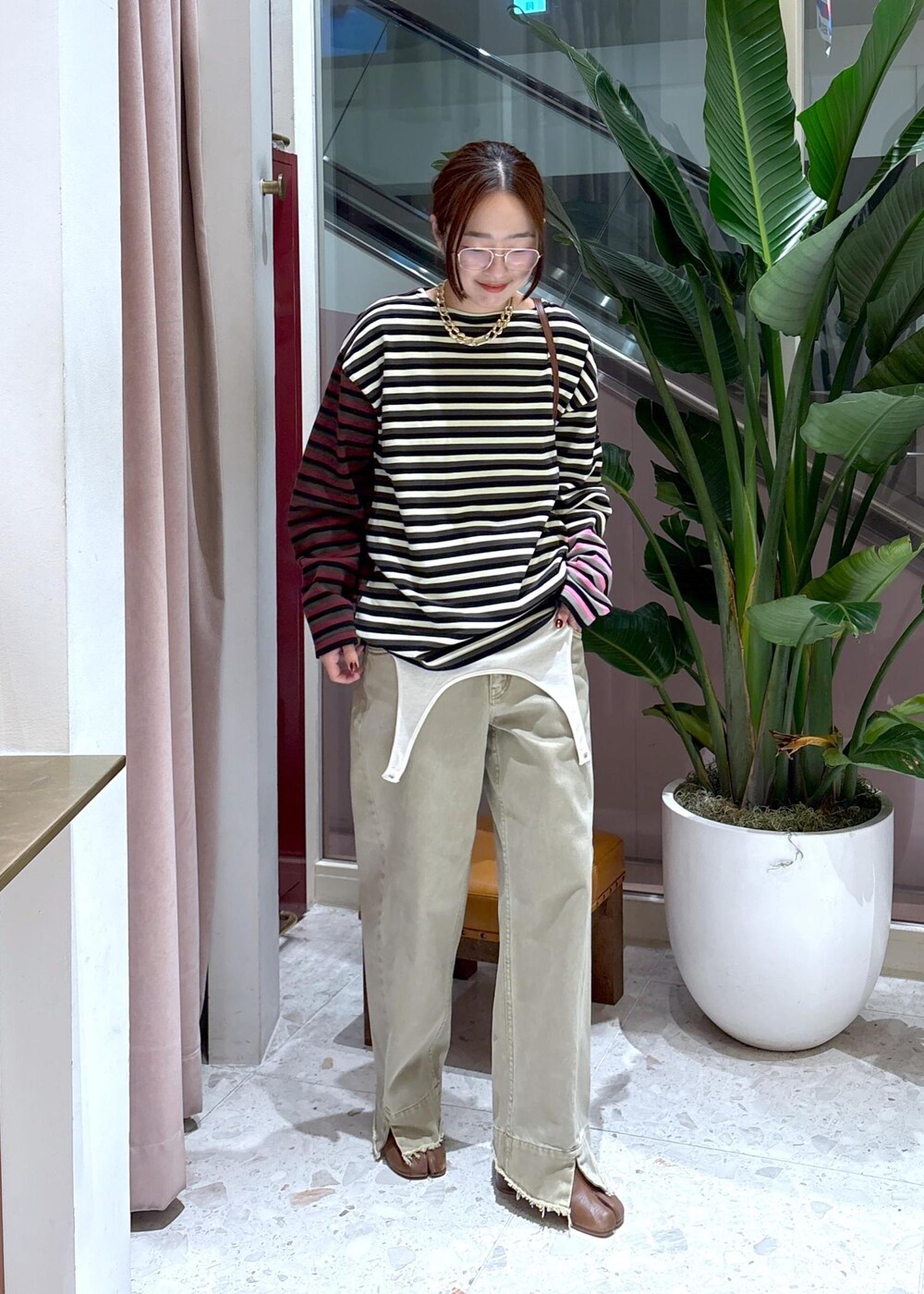 ベージュ系のデニムパンツ、グリーン系のTシャツ/カットソー、ホワイト系のTシャツ/カットソーを着用したレディースの秋コーディネートの2枚目の写真
