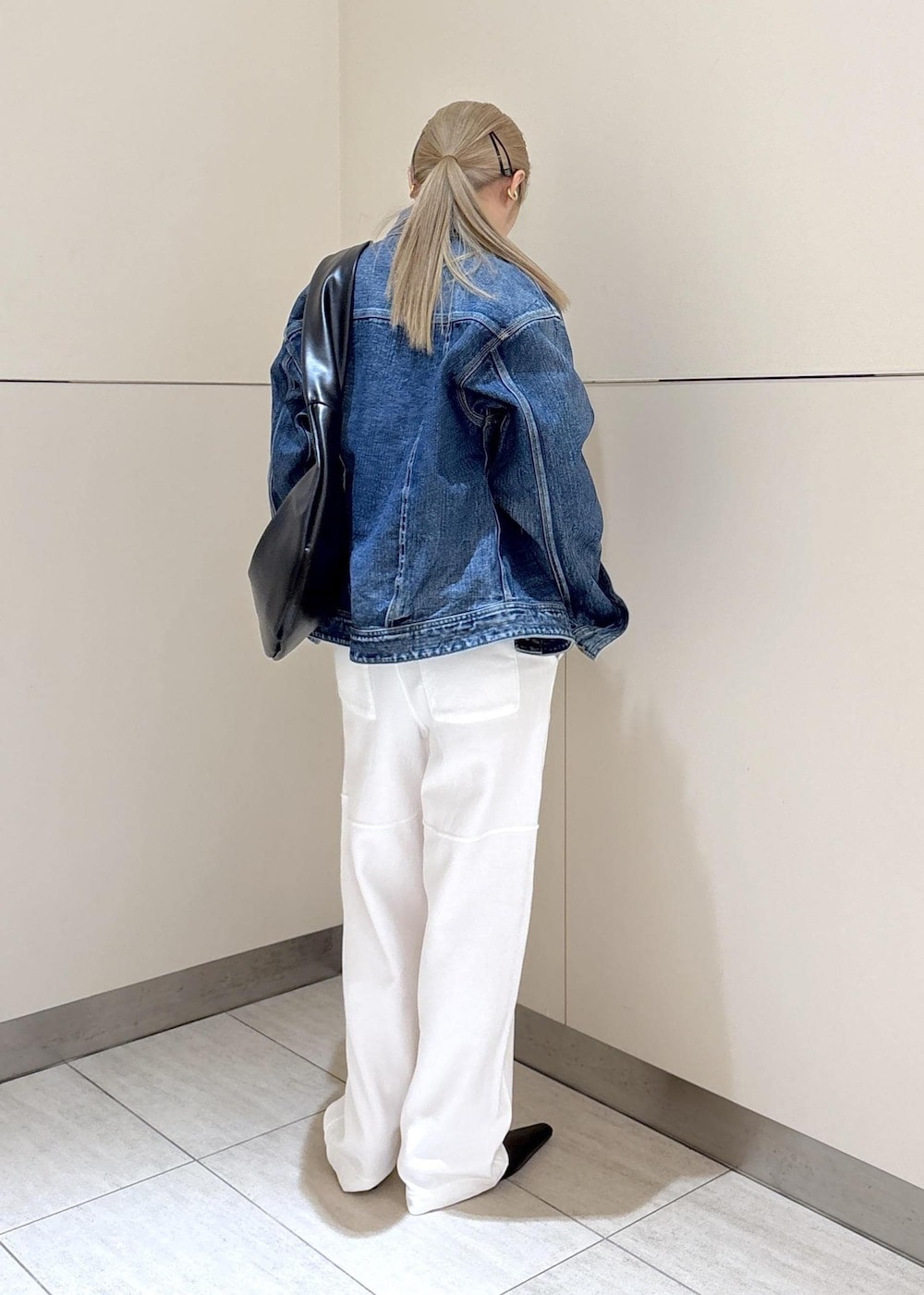 ブラック系のショルダーバッグ、ホワイト系のTシャツ/カットソー、グリーン系のキャミソールを着用したレディースの冬コーディネートの3枚目の写真