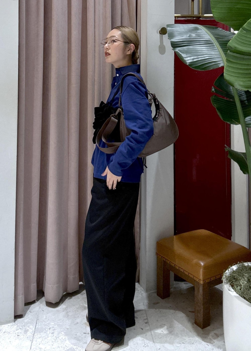 ブラウン系のショルダーバッグ、ブラック系のデニムパンツ、ブラック系のベストを着用したレディースの冬コーディネートの3枚目の写真