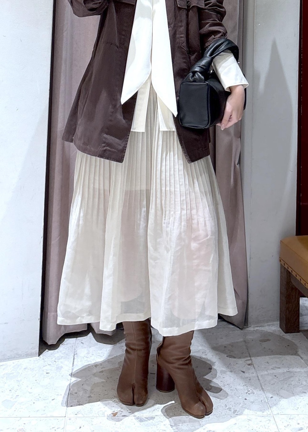 ブラック系のハンドバッグ、ホワイト系のシャツ/ブラウスを着用したレディースの春コーディネートの4枚目の写真