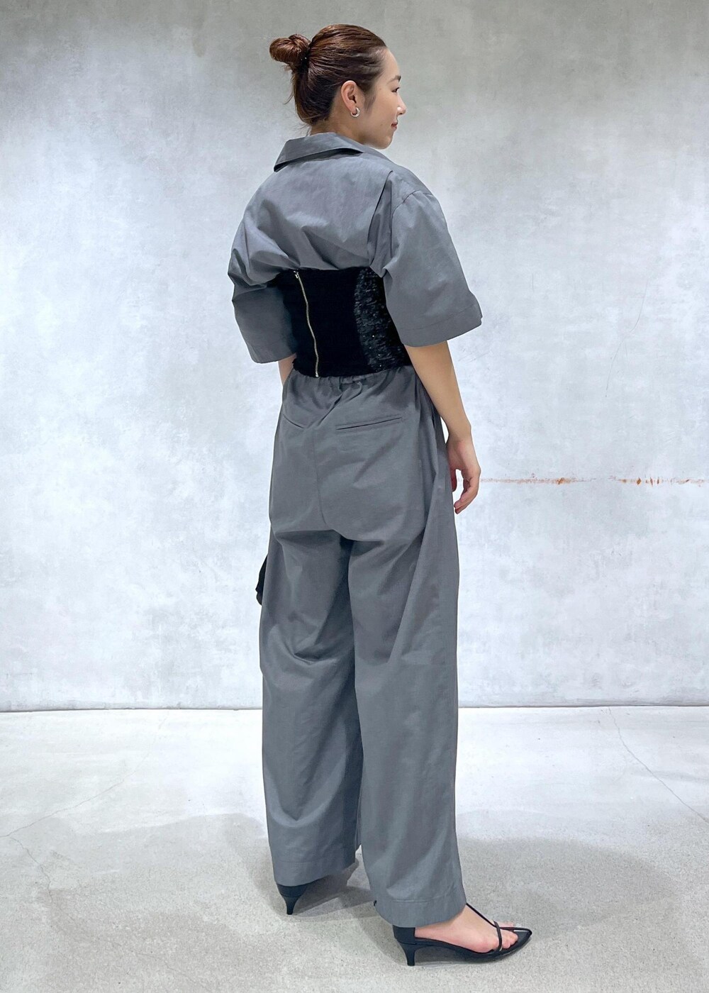ブラック系のサンダル、ブラック系のハンドバッグ、グレー系のつなぎ/オールインワンを着用したレディースの春コーディネートの3枚目の写真