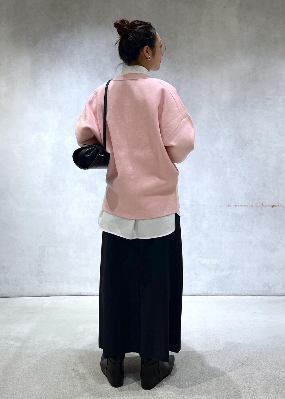 ブラック系のショルダーバッグ、ブラック系のブーツ、ピンク系のカーディガン/ボレロを着用したレディースの秋コーディネートの3枚目の写真