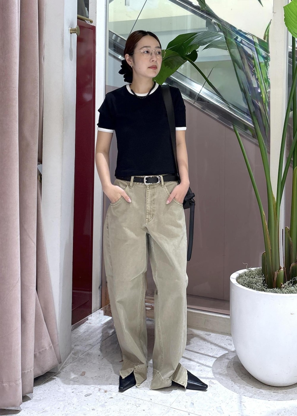 ブラック系のショルダーバッグ、ベージュ系のデニムパンツ、ブラック系のサンダルを着用したレディースの夏コーディネートの4枚目の写真