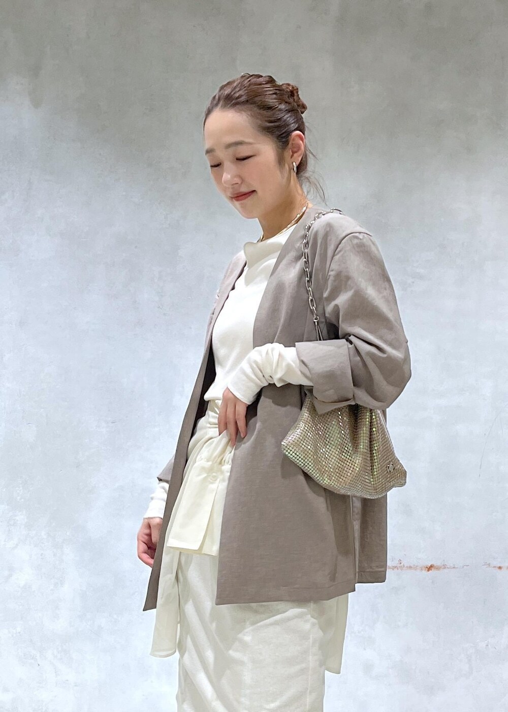 ベージュ系のセットアップ、ブラック系のデニムパンツ、その他のハンドバッグを着用したレディースの春コーディネートの4枚目の写真