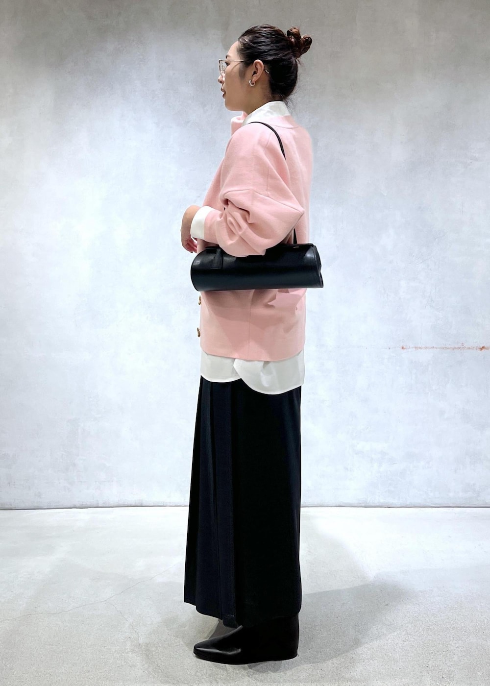 ブラック系のショルダーバッグ、ブラック系のブーツ、ピンク系のカーディガン/ボレロを着用したレディースの秋コーディネートの2枚目の写真