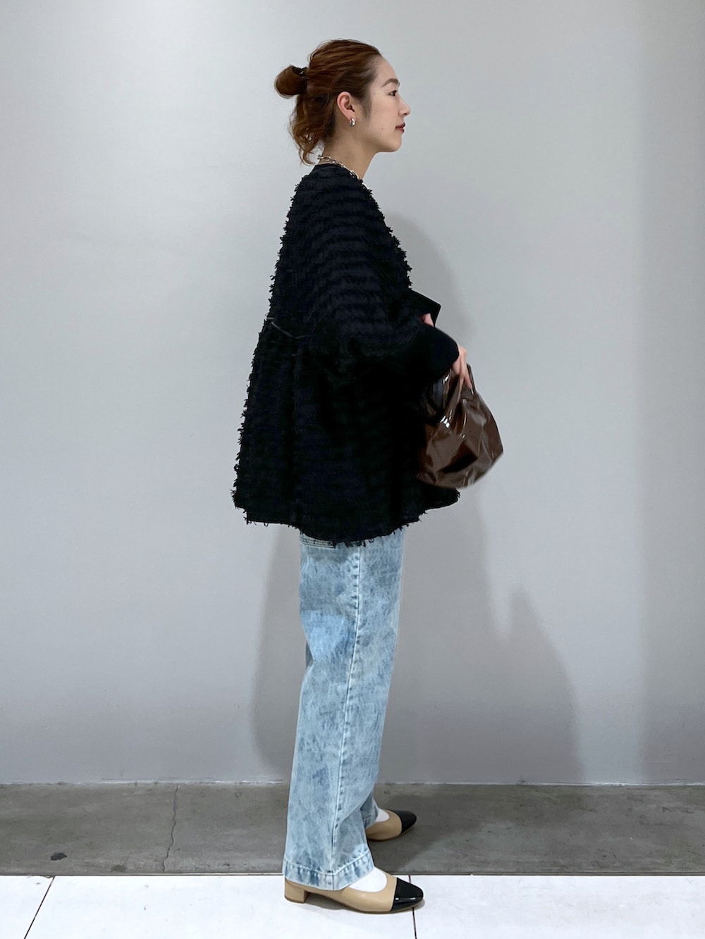 ブラック系のシャツ/ブラウス、ブルー系のデニムパンツ、ベージュ系のパンプスを着用したレディースの冬コーディネートの2枚目の写真