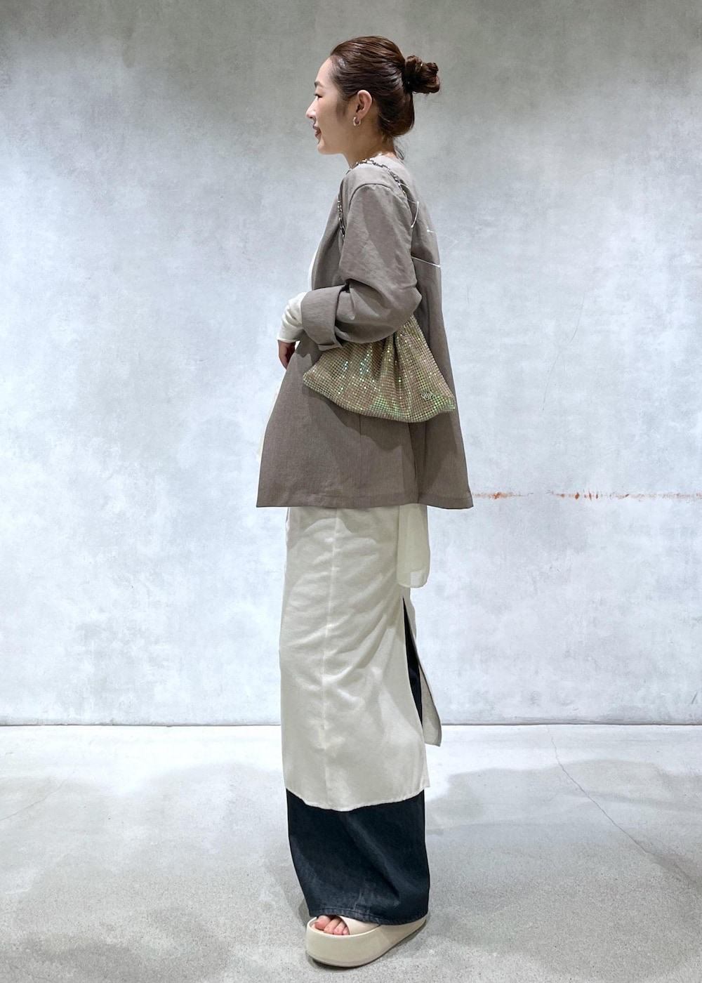 ベージュ系のセットアップ、ブラック系のデニムパンツ、その他のハンドバッグを着用したレディースの春コーディネートの2枚目の写真