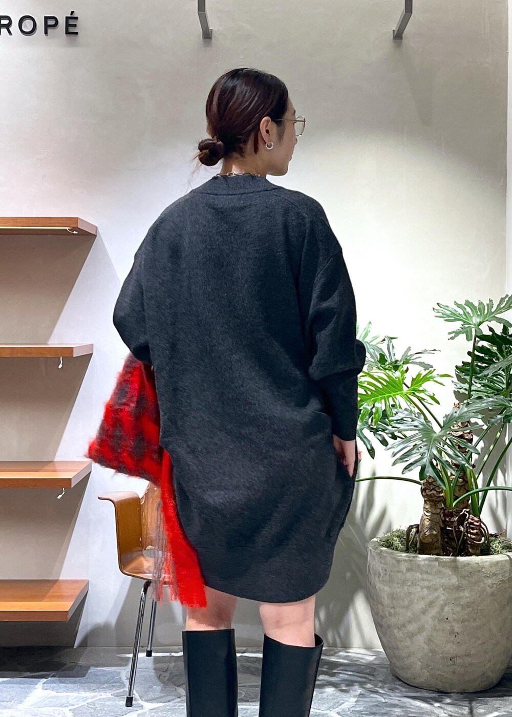 ブラック系のブーツ、グレー系のニット/セーター、ブラック系のハンドバッグを着用したレディースの秋コーディネートの6枚目の写真