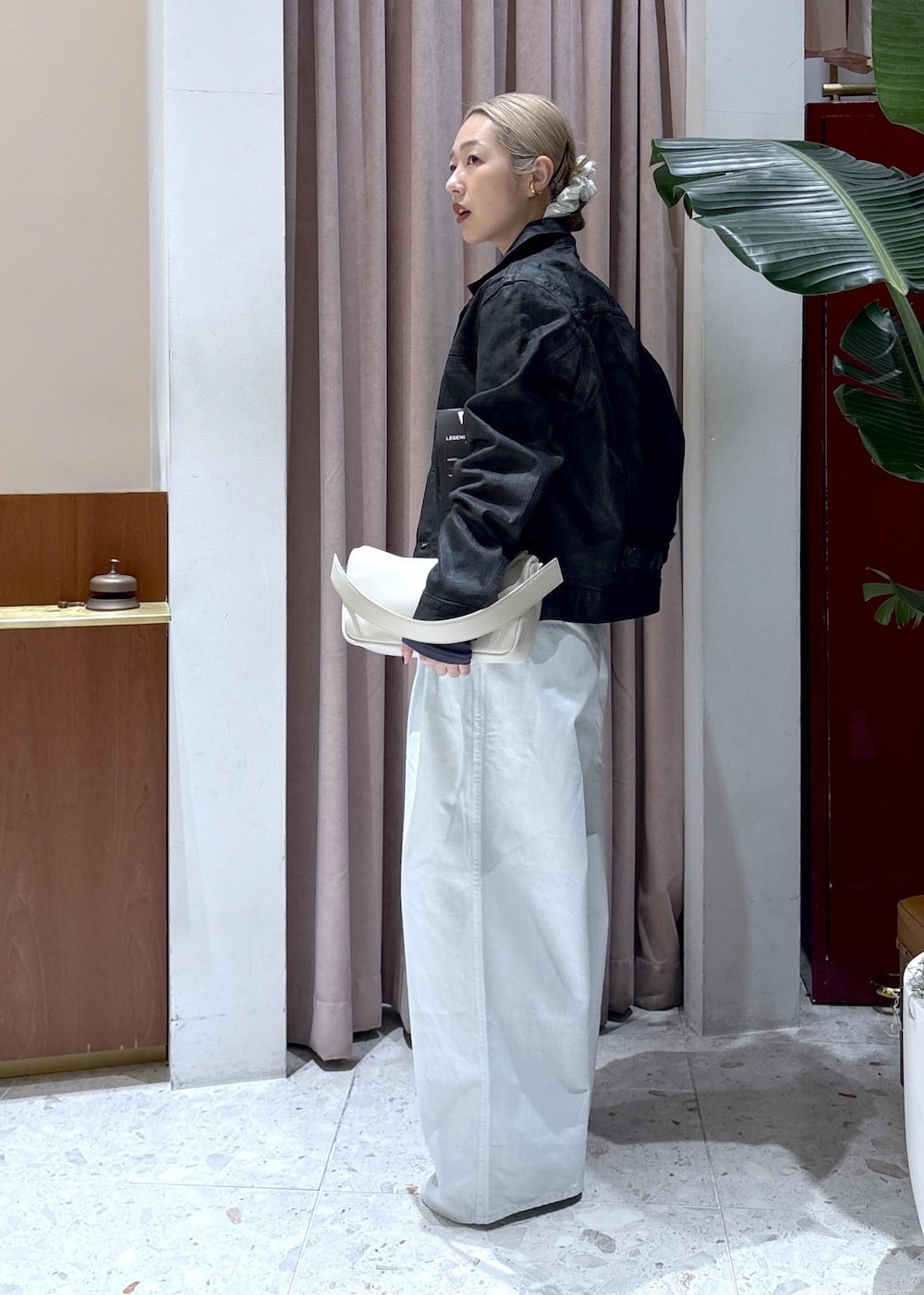 ホワイト系のハンドバッグ、グレー系のTシャツ/カットソー、ブルー系のデニムパンツを着用したレディースの冬コーディネートの2枚目の写真