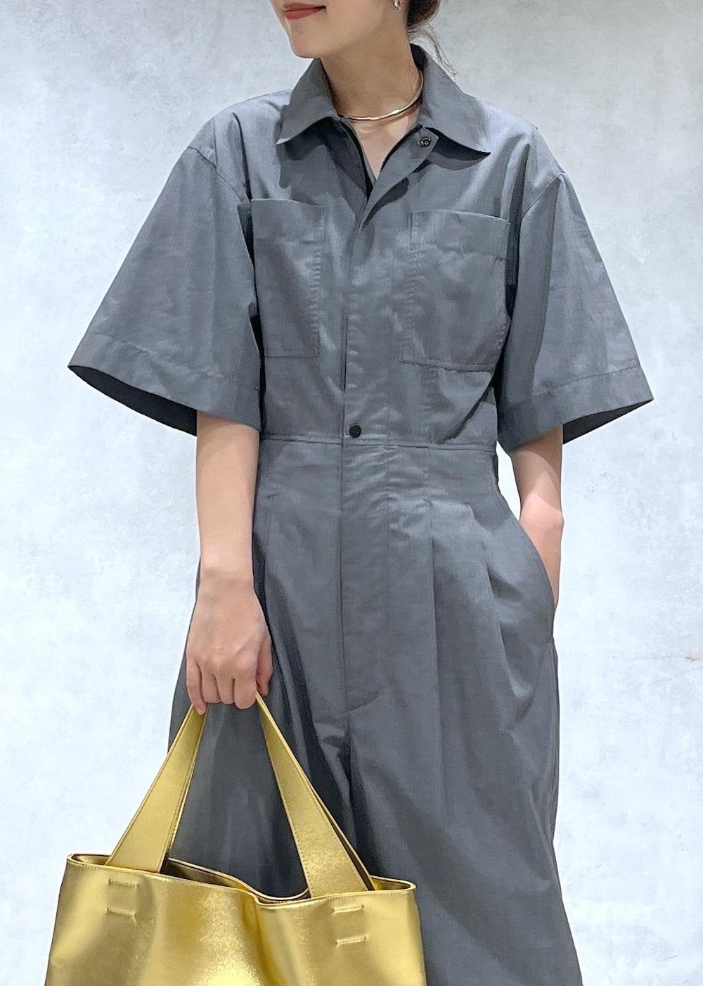 ブラック系のサンダル、ゴールド系のトートバッグ、グレー系のつなぎ/オールインワンを着用したレディースの春コーディネートの4枚目の写真