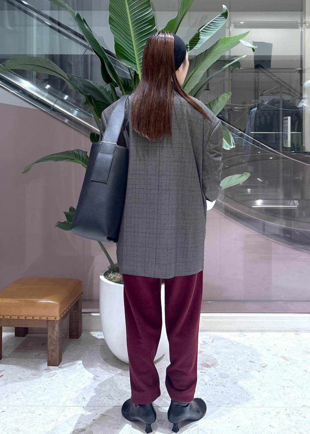 ブラック系のショルダーバッグ、ホワイト系のシャツ/ブラウス、ブラック系のブーツを着用したレディースの秋コーディネートの2枚目の写真