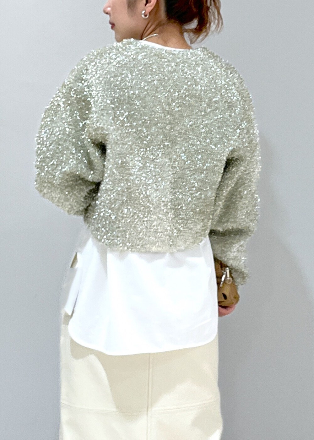 ホワイト系のスカート、ベージュ系のブーツ、ホワイト系のTシャツ/カットソーを着用したレディースの冬コーディネートの4枚目の写真