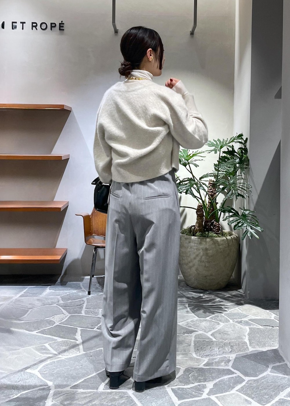 ホワイト系のカーディガン/ボレロ、ホワイト系のニット/セーター、ブラック系のショルダーバッグを着用したレディースの冬コーディネートの3枚目の写真