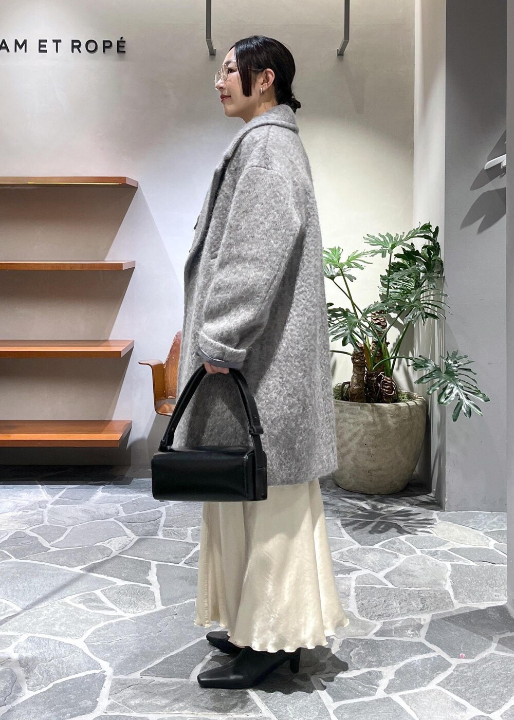 ブラック系のブーツ、ベージュ系のスカート、ブラック系のカーディガン/ボレロを着用したレディースの冬コーディネートの2枚目の写真