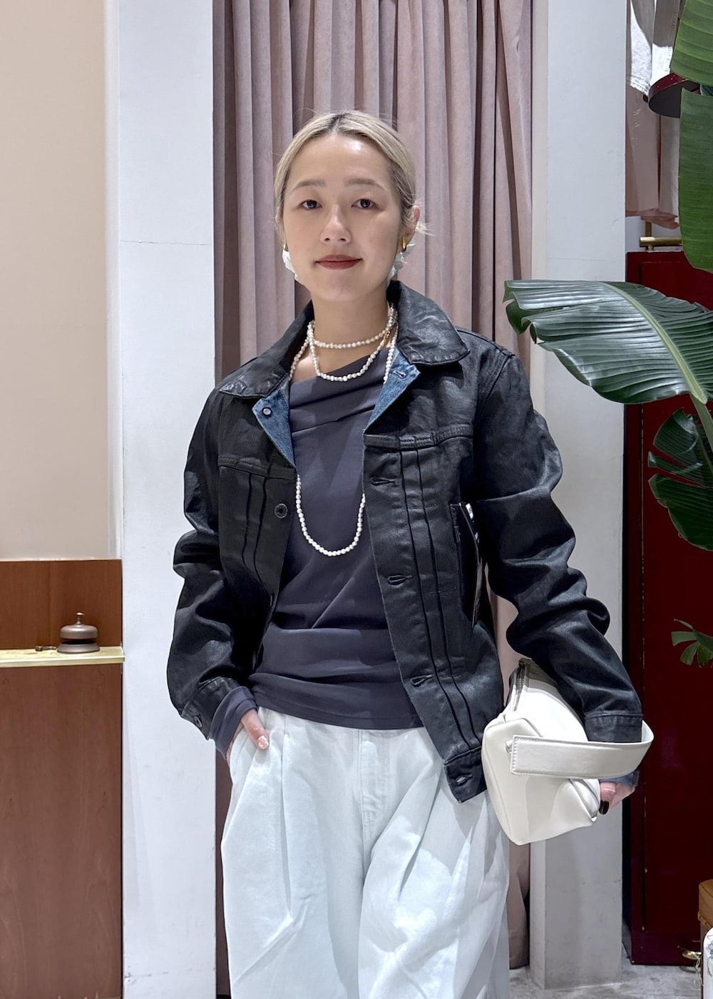 ホワイト系のハンドバッグ、グレー系のTシャツ/カットソー、ブルー系のデニムパンツを着用したレディースの冬コーディネートの5枚目の写真