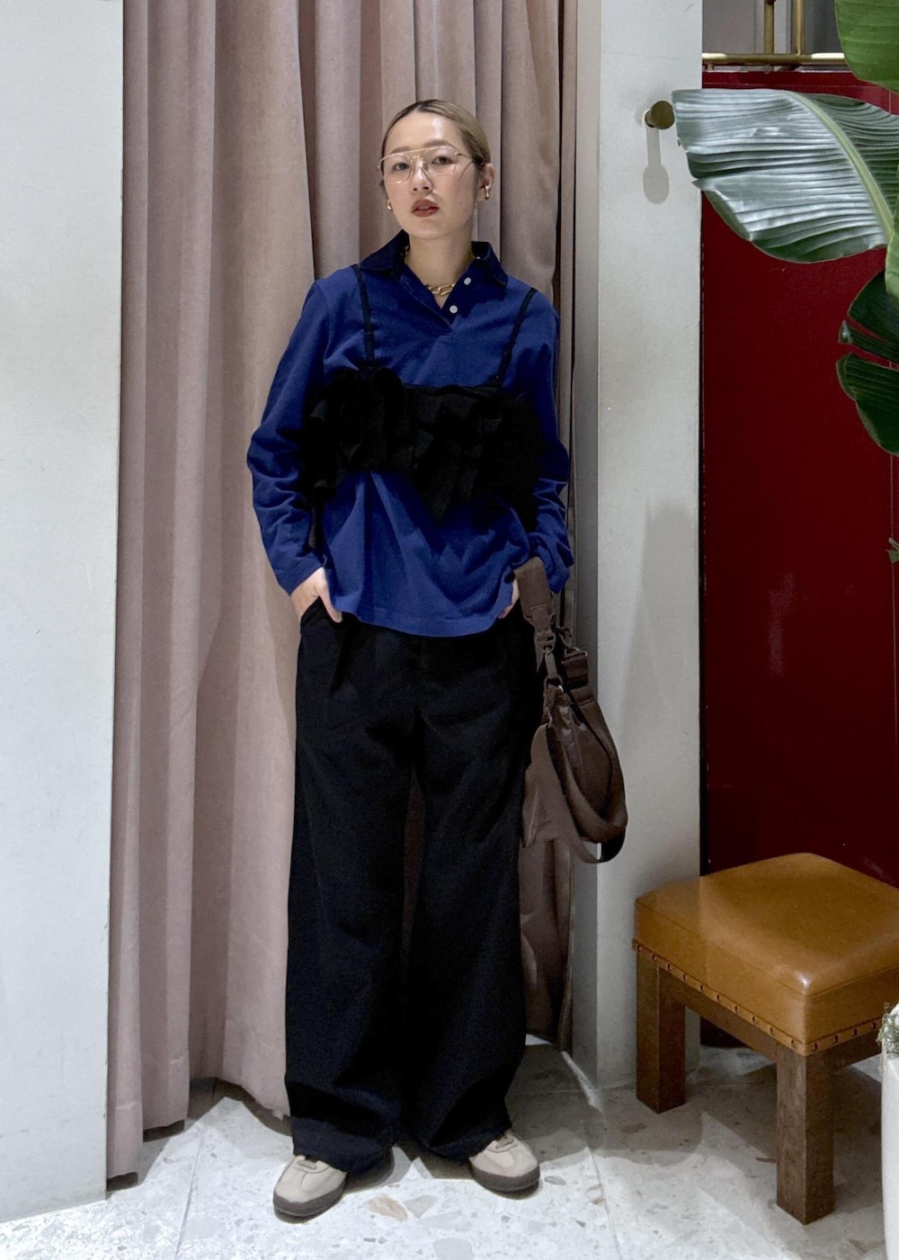 ブラウン系のショルダーバッグ、ブラック系のデニムパンツ、ブラック系のベストを着用したレディースの冬コーディネートの2枚目の写真