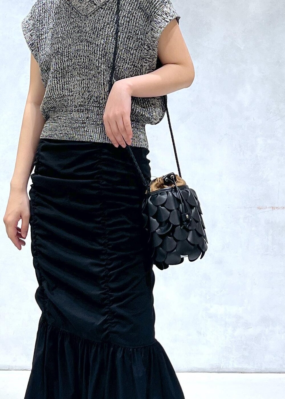 ブラック系のサンダル、ブラック系のスカート、ブラック系のベストを着用したレディースの春コーディネートの6枚目の写真