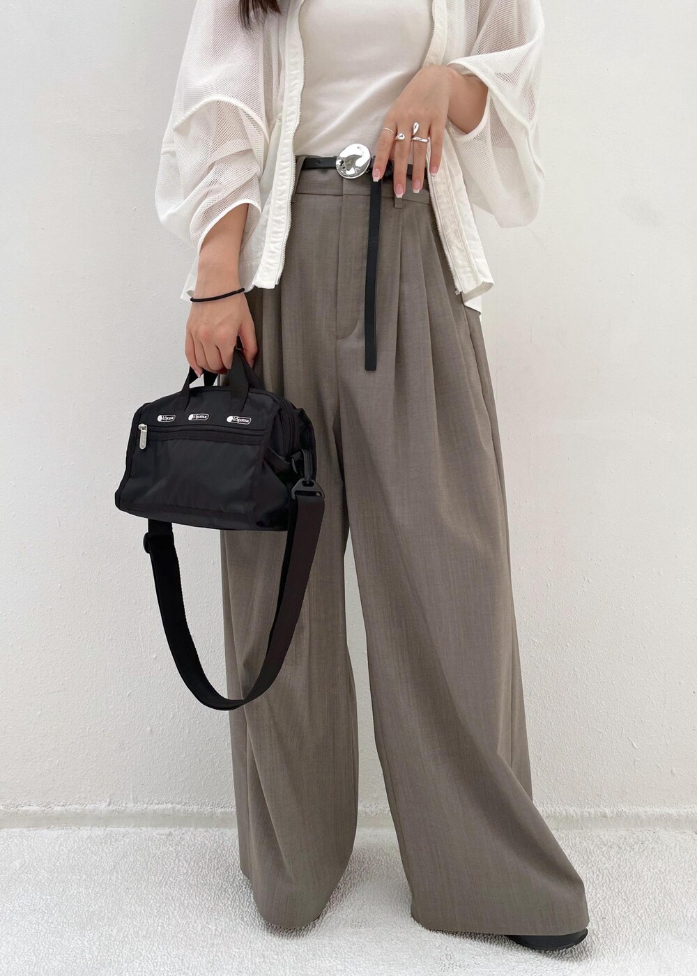 グレー系のスラックス、ホワイト系のカーディガン/ボレロを着用したレディースの春コーディネートの6枚目の写真