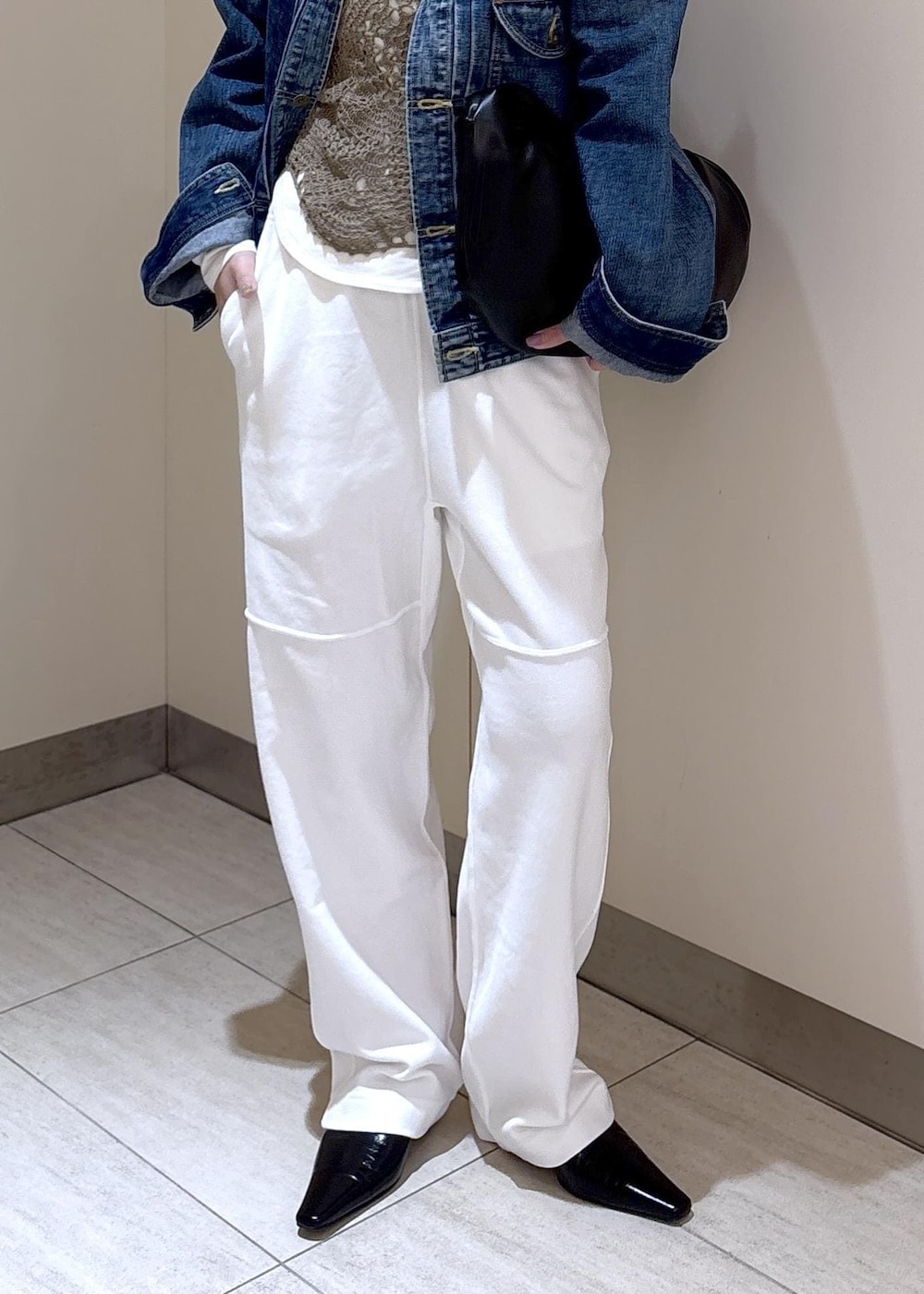 ブラック系のショルダーバッグ、ホワイト系のTシャツ/カットソー、グリーン系のキャミソールを着用したレディースの冬コーディネートの6枚目の写真