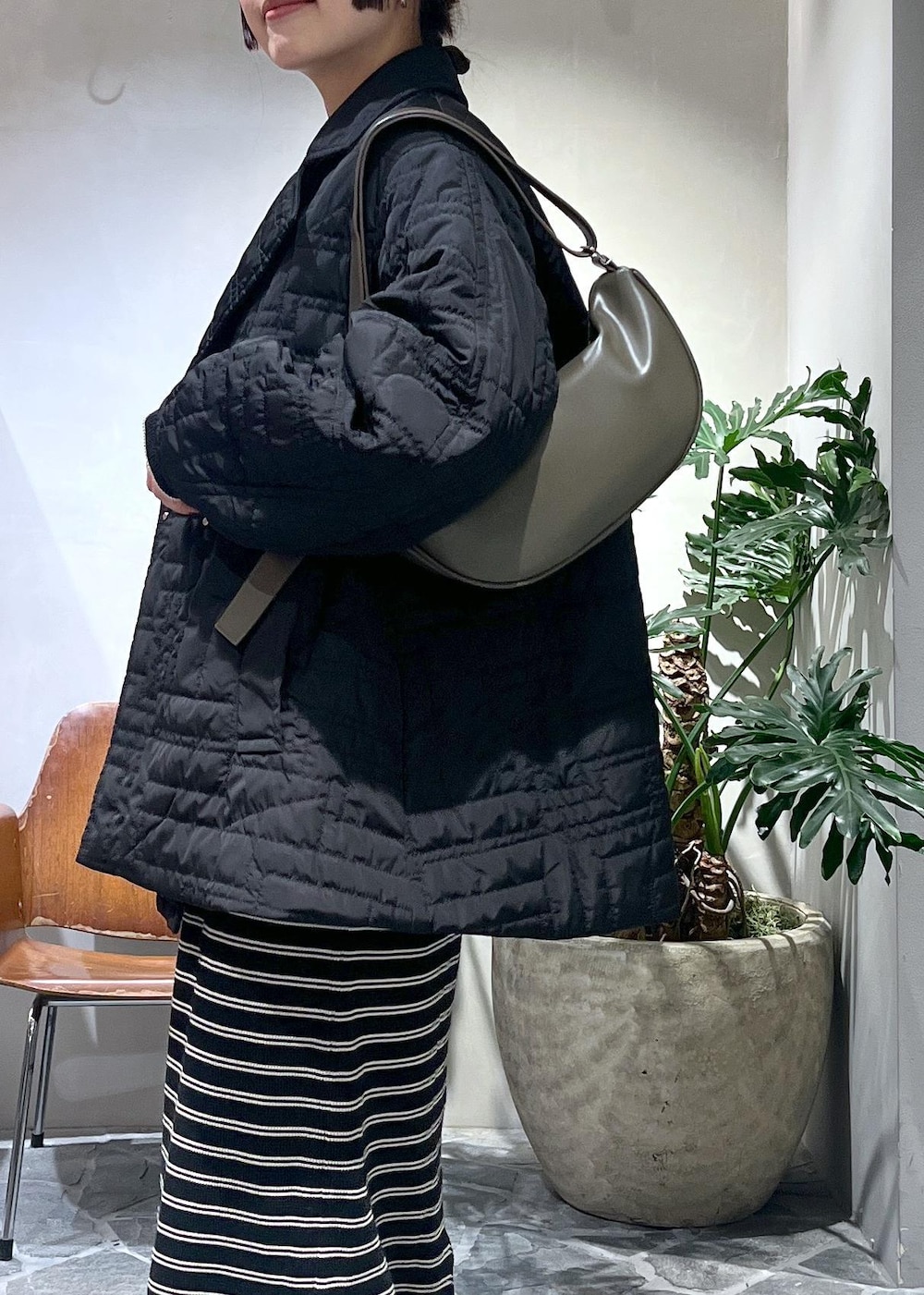 ブラック系のワンピース、グリーン系のショルダーバッグ、ブラック系のブルゾンを着用したレディースの冬コーディネートの4枚目の写真