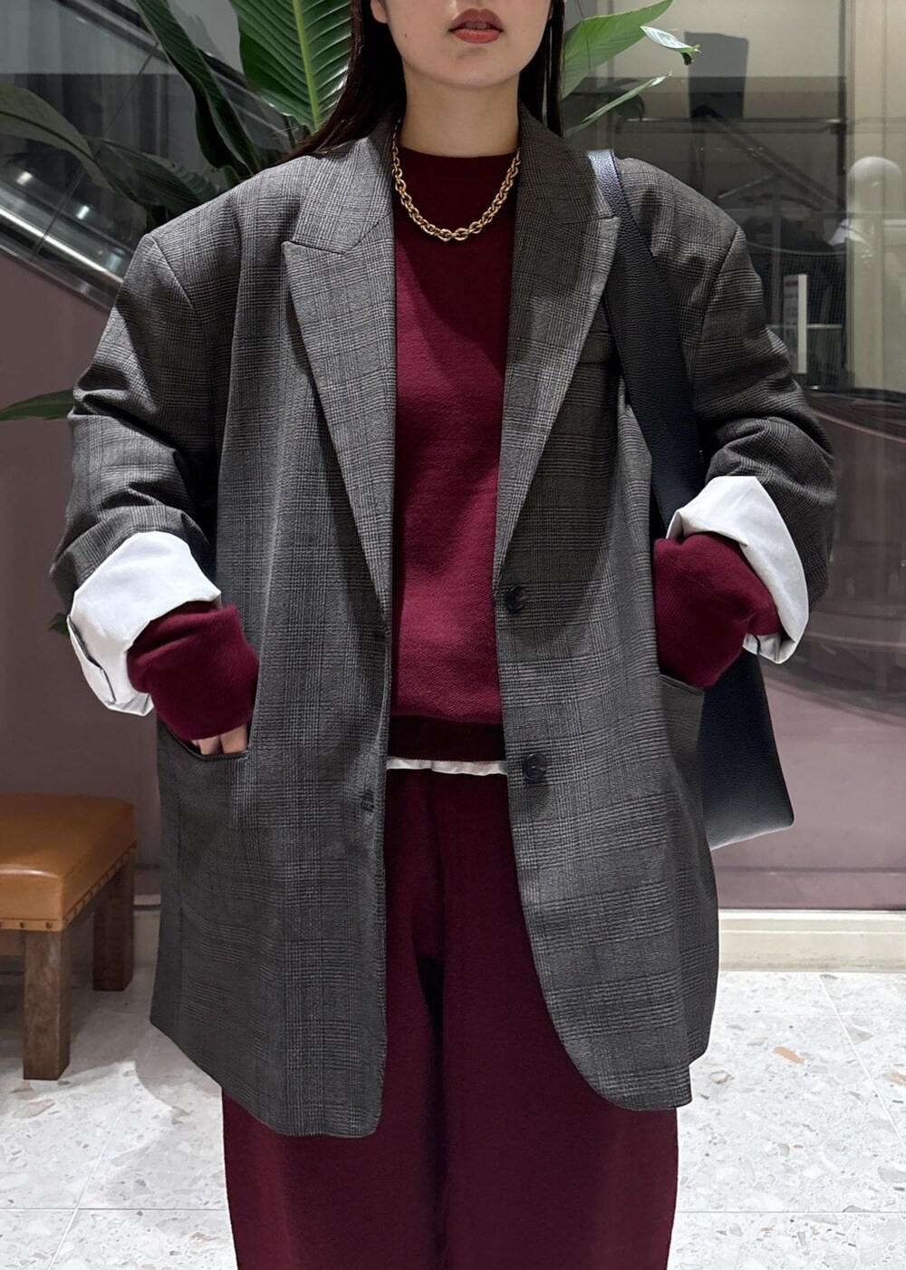 ブラック系のショルダーバッグ、ホワイト系のシャツ/ブラウス、ブラック系のブーツを着用したレディースの秋コーディネートの4枚目の写真