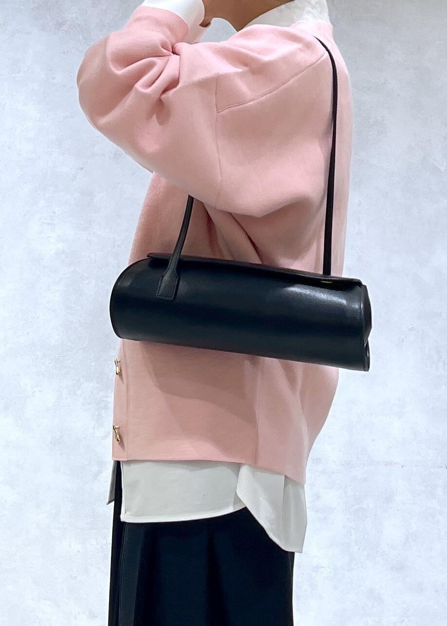 ブラック系のショルダーバッグ、ブラック系のブーツ、ピンク系のカーディガン/ボレロを着用したレディースの秋コーディネートの5枚目の写真