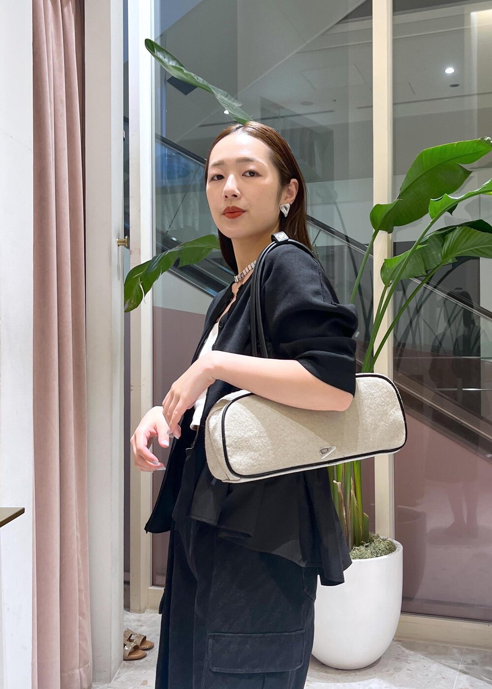 ベージュ系のサンダル、ホワイト系のボストンバッグ、ブラック系のカーディガン/ボレロを着用したレディースの春コーディネートの5枚目の写真