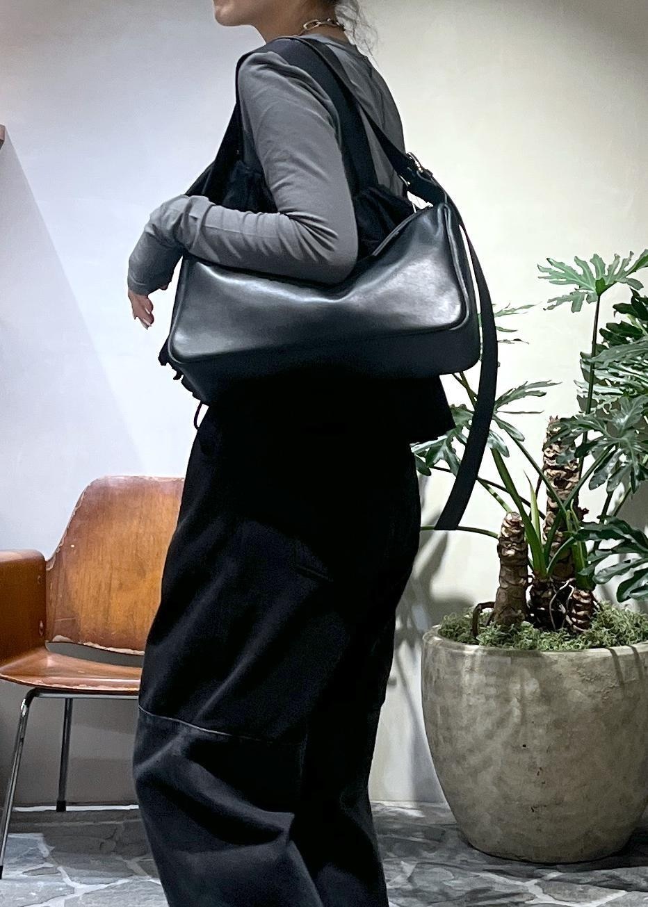 ブラック系のショルダーバッグ、ブラック系のベストを着用したレディースの冬コーディネートの6枚目の写真